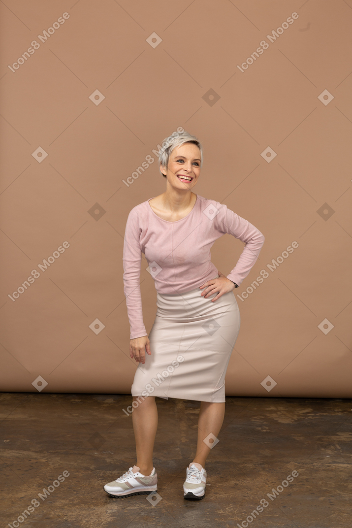 Vista frontal de uma mulher com roupas casuais, posando com a mão no quadril