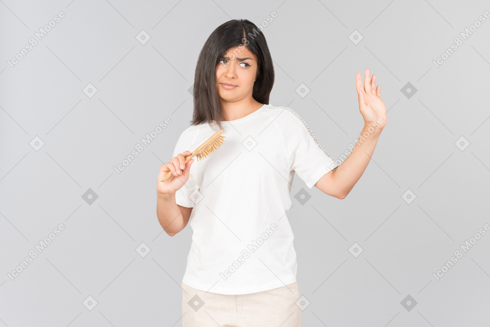 Dissatisfied young indian woman holding hairbrush