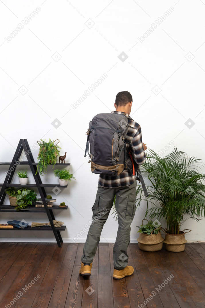 Three-quarter back view of a tourist with a backpack
