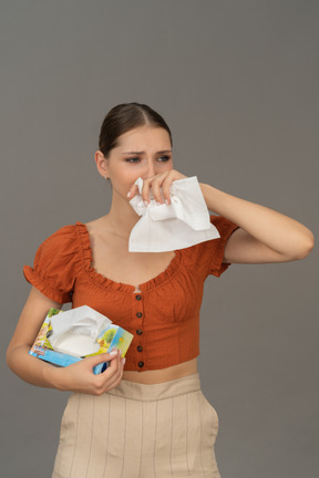 Front view of young woman crying with tissue in hands