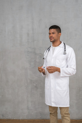 Male doctor holding a thermometer