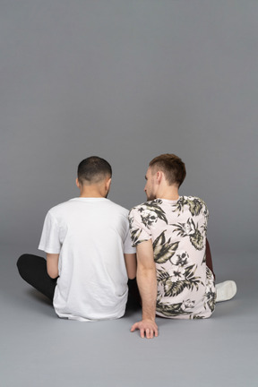 坐在地板上的两个年轻人的背影