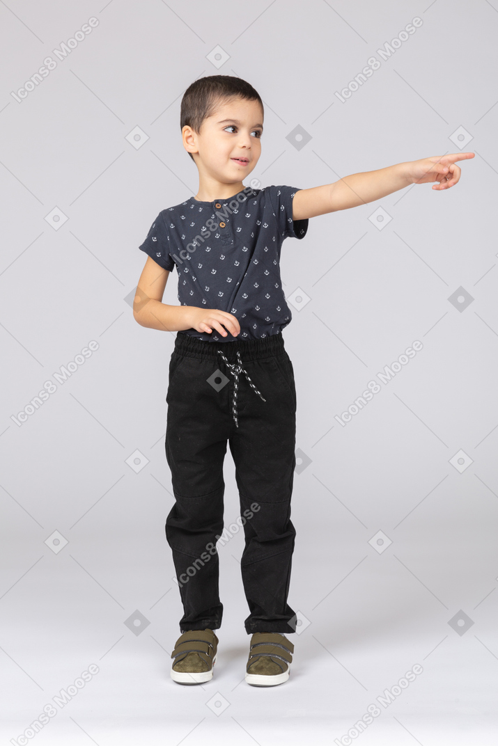 Front view of a cute boy pointing with a finger