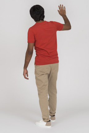 Back view of young man waving