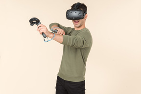 Young caucasian guy playing a virtual reality game