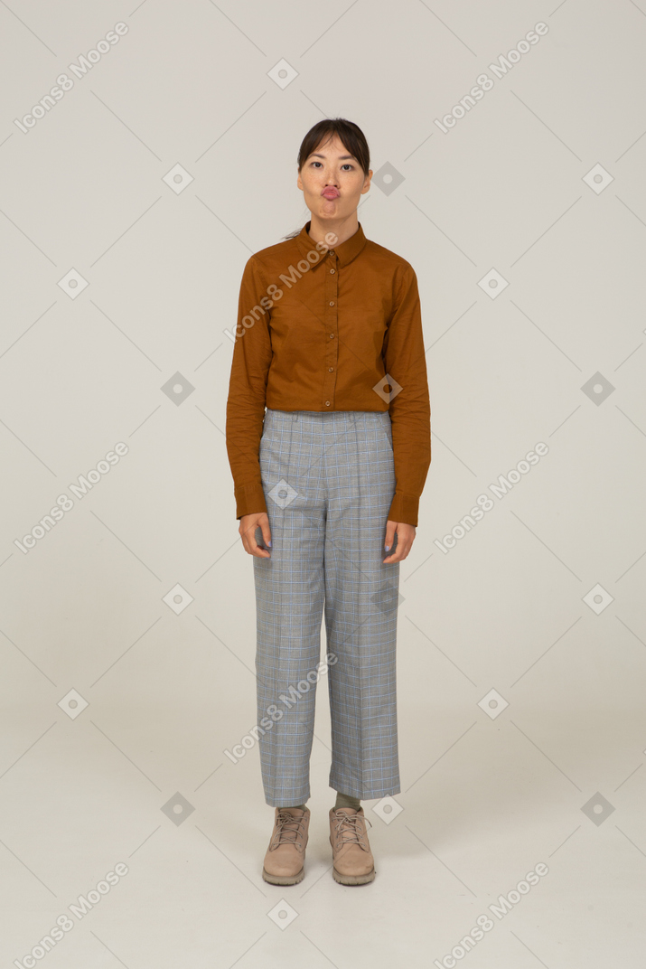 Front view of a naughty pouting young asian female in breeches and blouse