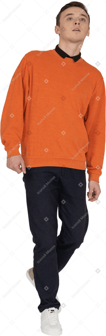 Young man in orange sweatshirt walking