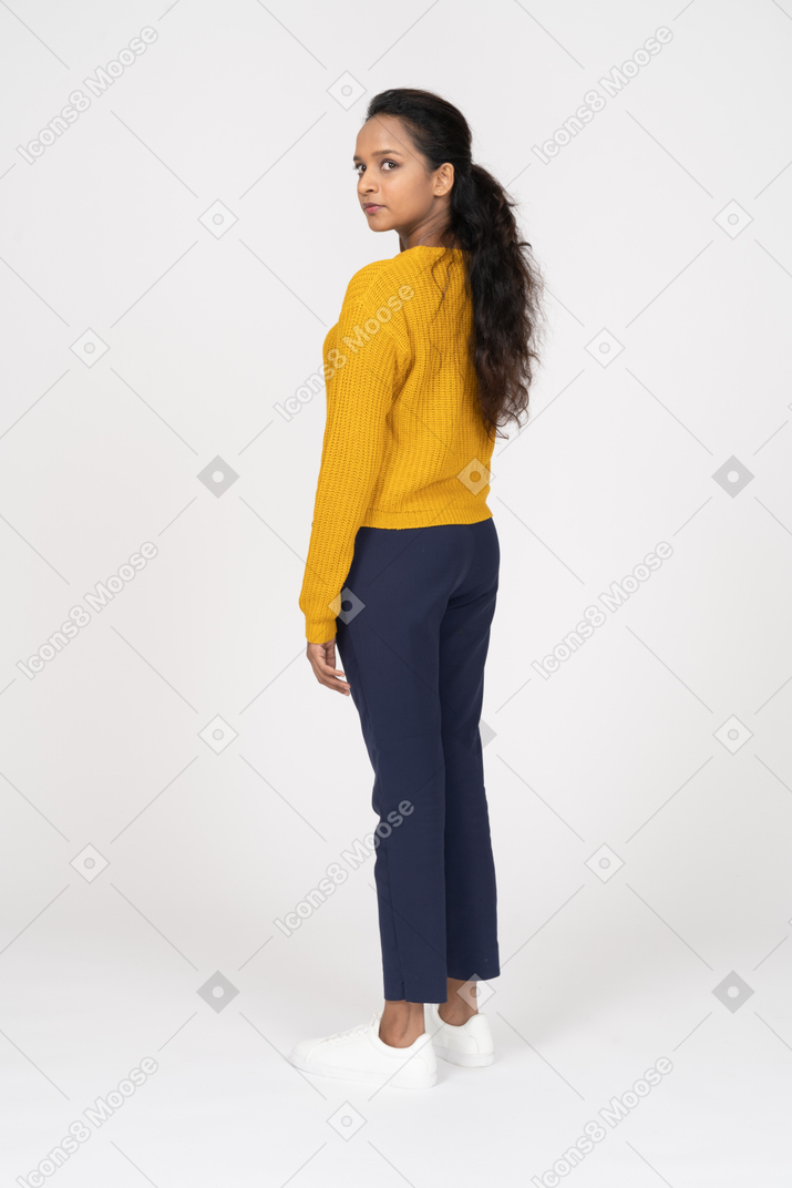 Rear view of a girl in casual clothes looking at camera