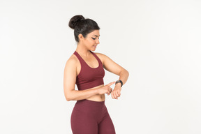 Indian girl in sporstwear checking fitness tracker