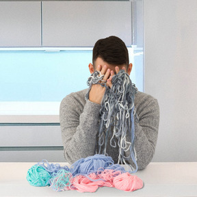 A person sitting at a table with a bunch of yarn