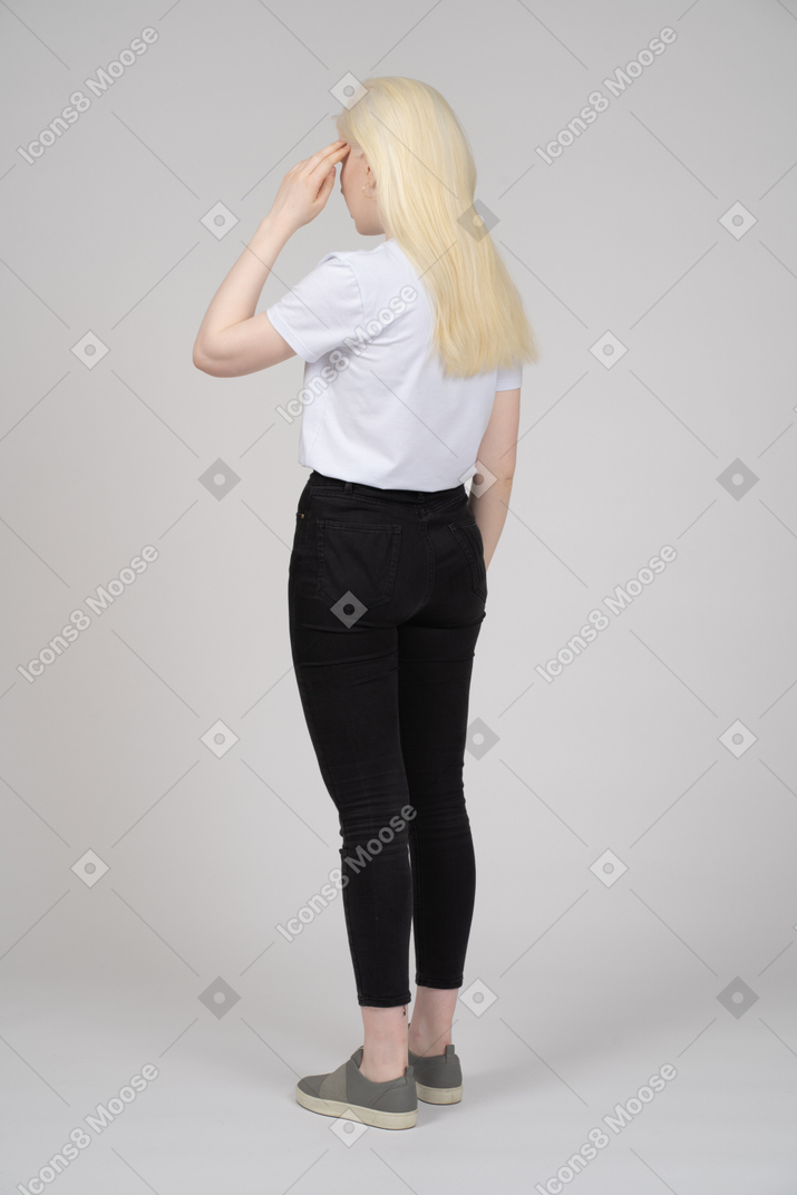 Rear view of a young girl touching her head