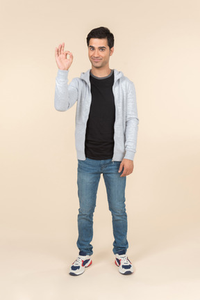 Young caucasian man showing an ok sign