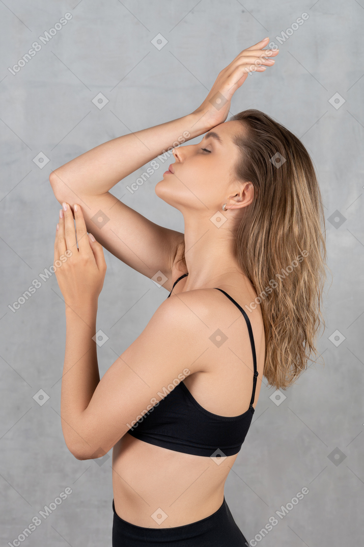 Young woman raising her hands while posing