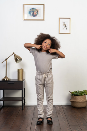 Good looking girl kid posing on the apartment background