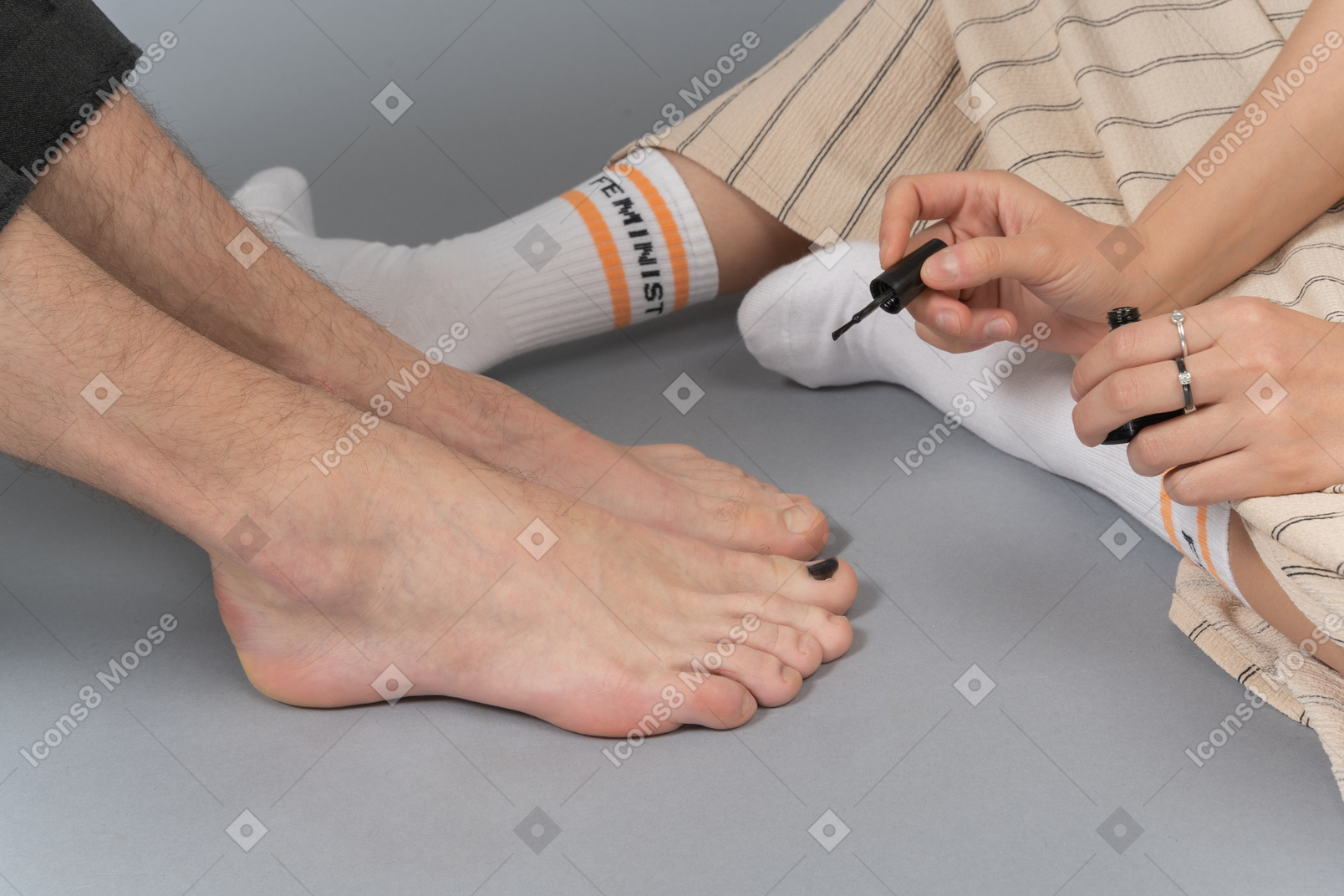 Женщина полирует мужские ногти на ногах