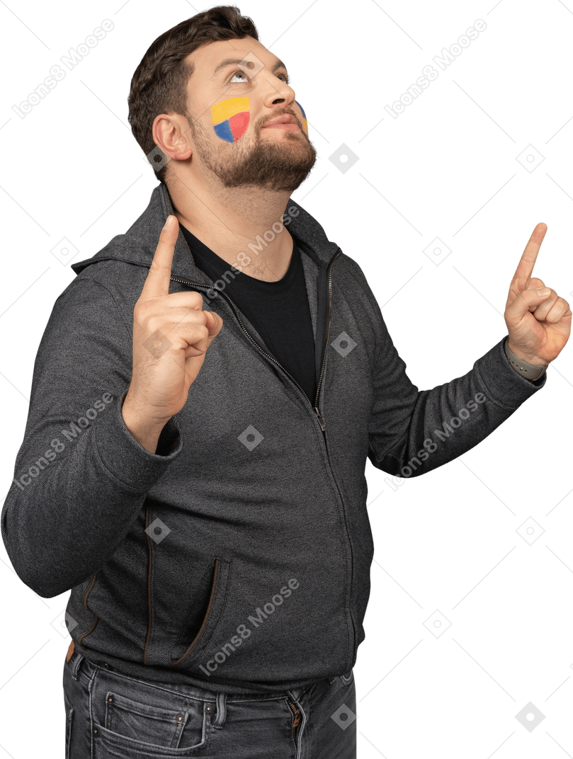 Three-quarter view of a male football fan with colorful face art raising fingers