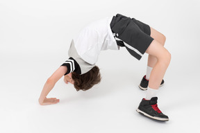 Ahtletic kid boy is doing  a backbend