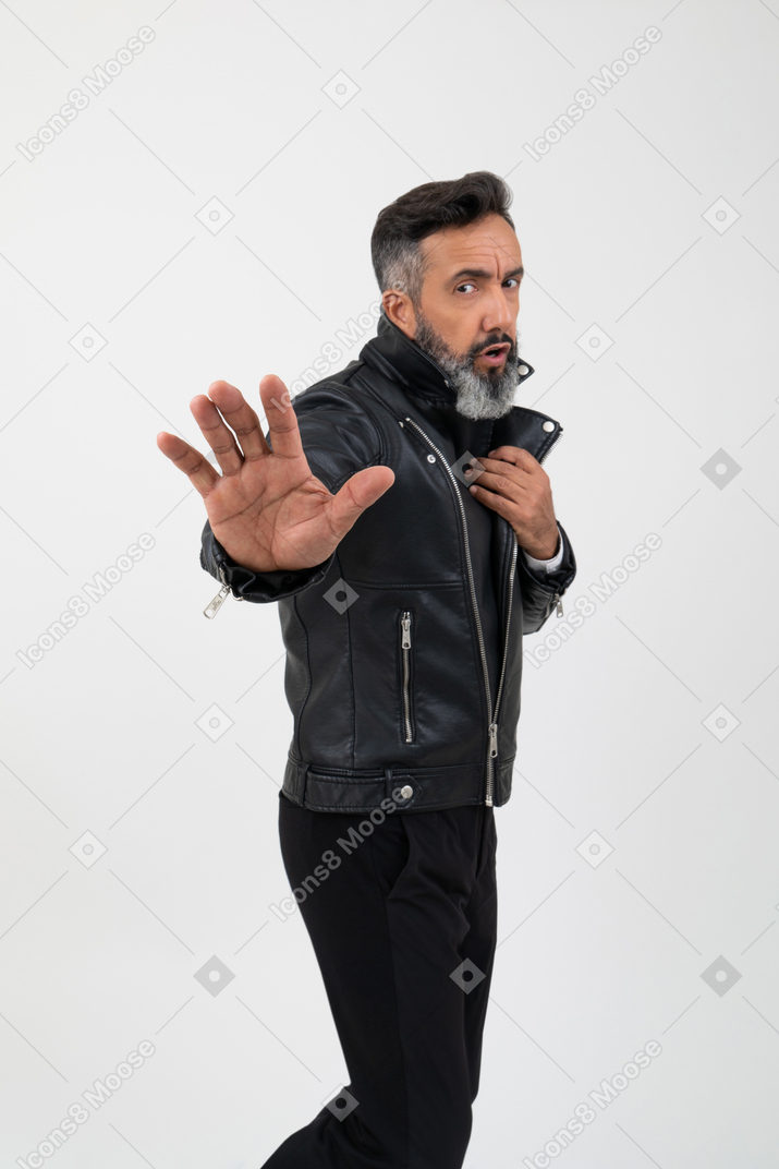 Handsome man touching his jacket with one hand and holding another pulled