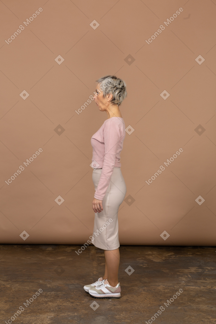 Vista laterale di una donna in abiti casual che fa smorfie