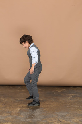Вид сбоку на танцующего мальчика в костюме