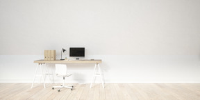 Work desk with computer monitor standing against a white wall