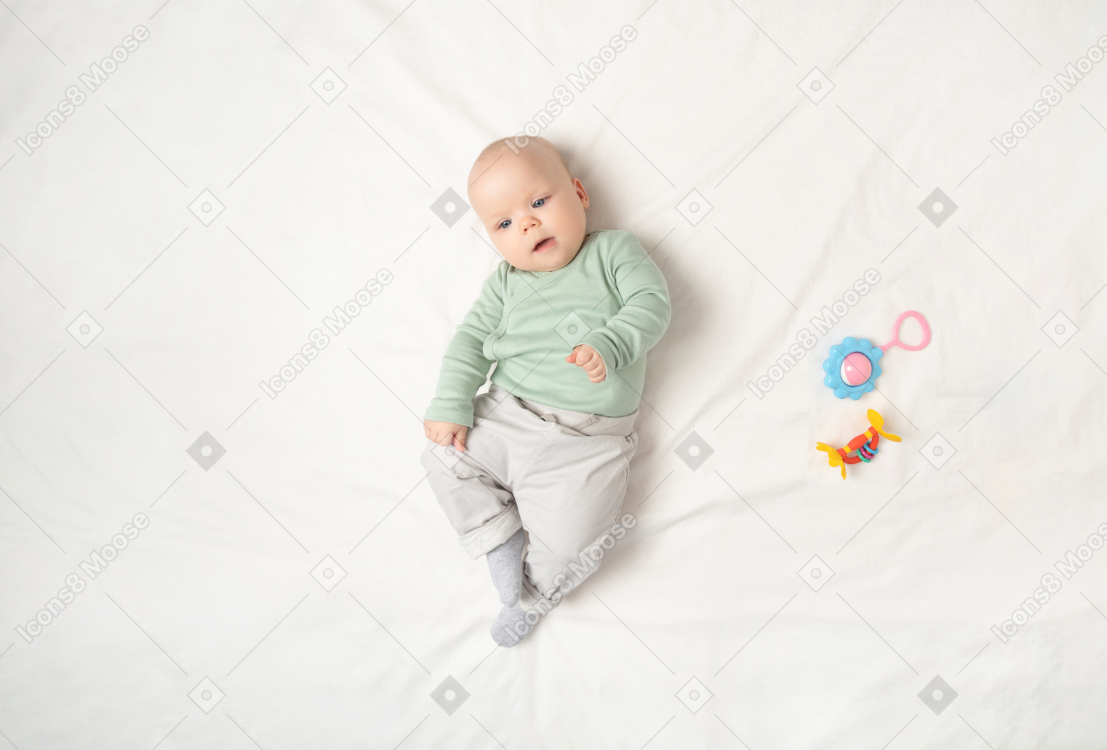 Baby girl lying on the back near children toys