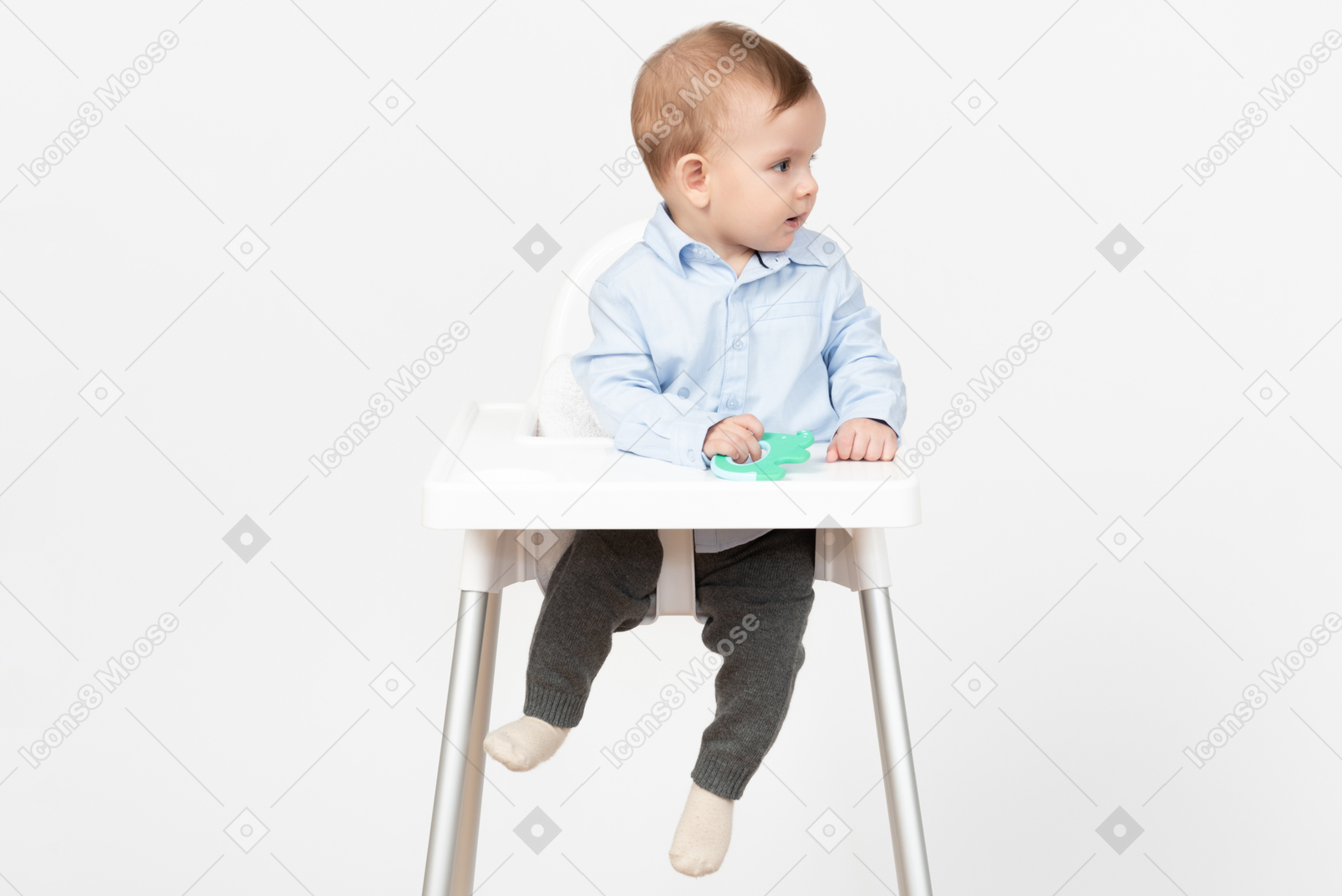 Baby boy sitting in highchair and holding toy