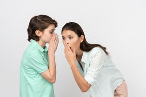 Chico atractivo compartiendo un secreto con su madre.