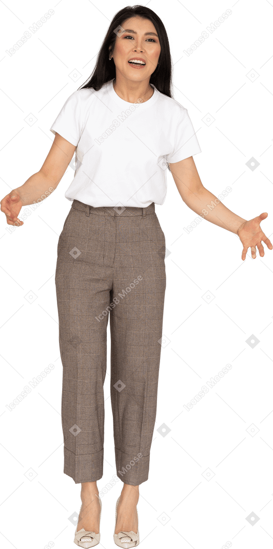 Vista frontal de una señorita quejándose en pantalones y camiseta extendiendo sus manos
