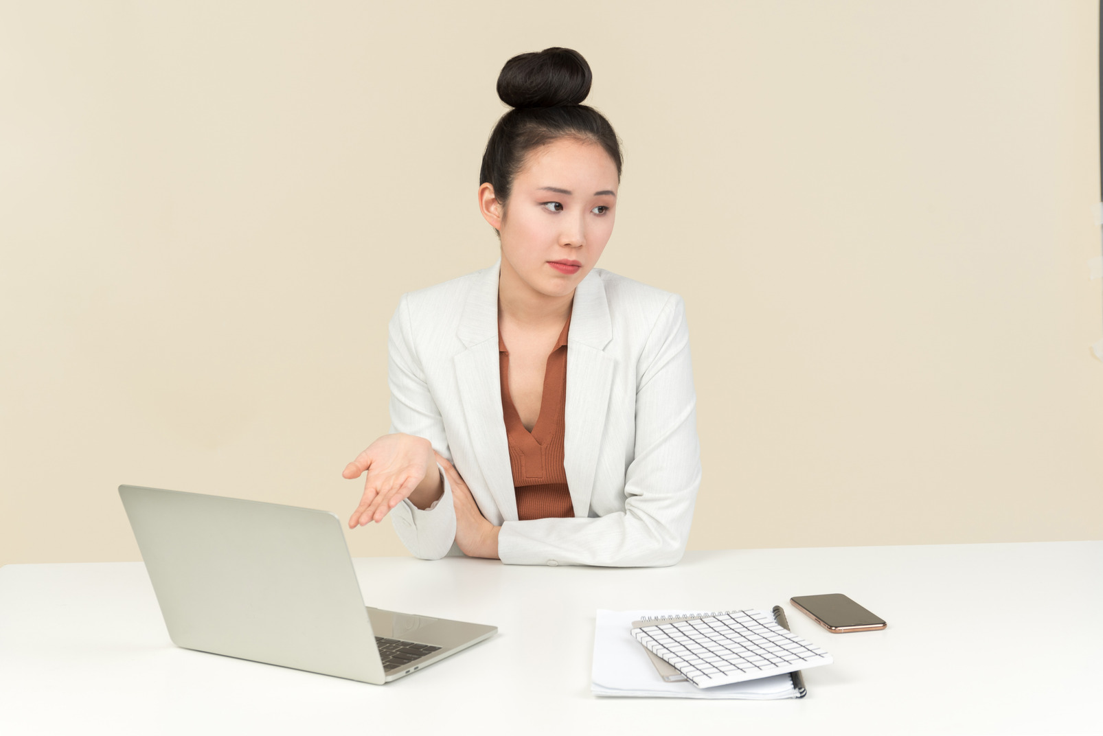 Young asian office worker sitting at the desk and pointing at laptop