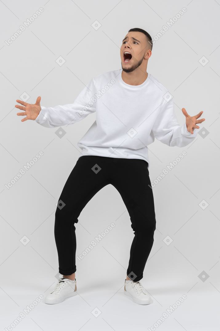 Young man in casual clothes panicking and screaming out
