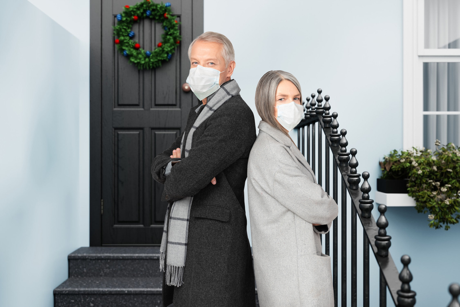 Senior socially responsible couple near a christmas decorated door