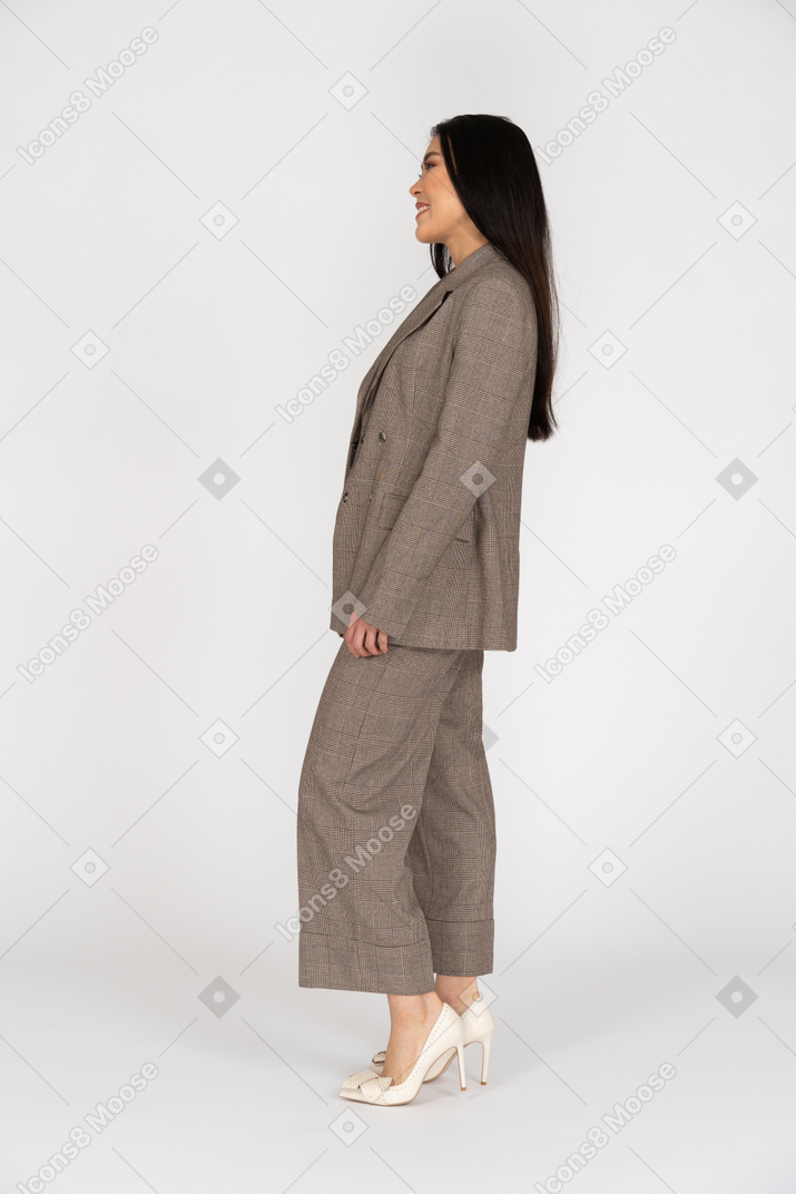 茶色のビジネススーツで笑っている若い女性の側面図