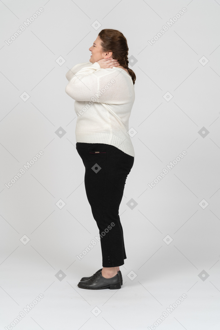 Женщина больших размеров в повседневной одежде страдает от боли в шее