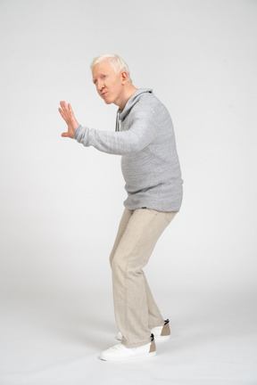 Hombre de vista lateral que muestra gesto de parada con la mano