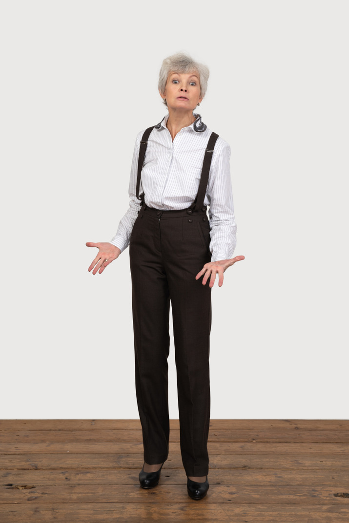 Front view of a gesticulating questioning old lady in office clothing