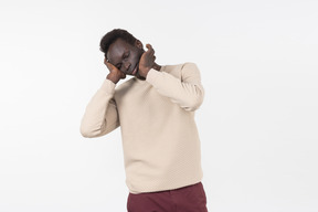 A young black man in a grey sweater standing alone on the white background