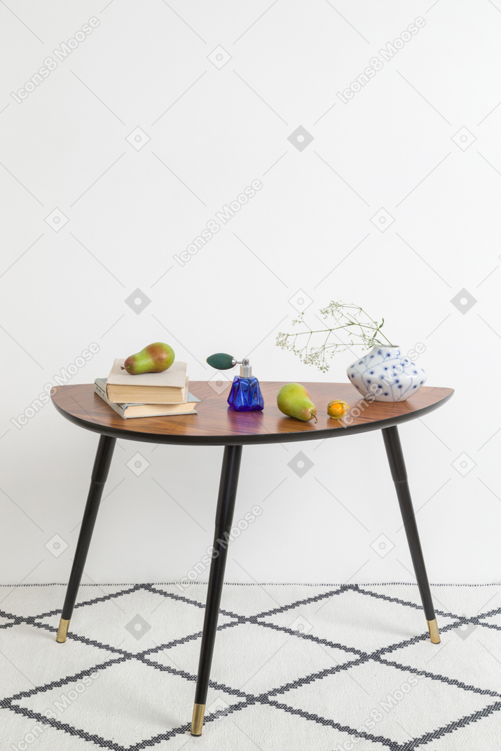 Books, pears, vintage vase with dried twig on vintage style coffee table