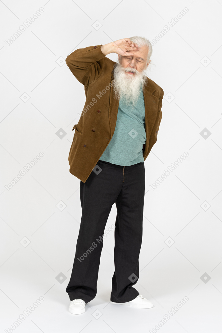 Old man touching his forehead and looking tired