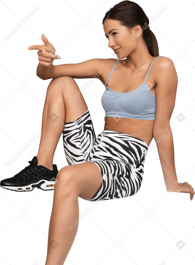 Positive female athlete gesticulating sitting on a cube