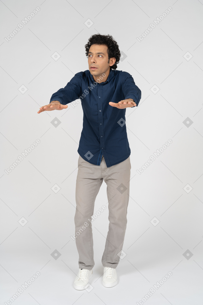 Vue de face d'un homme en vêtements décontractés debout avec les bras tendus