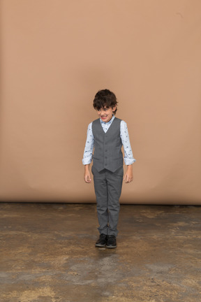 Vista frontale di un ragazzo in giacca e cravatta che guarda in basso
