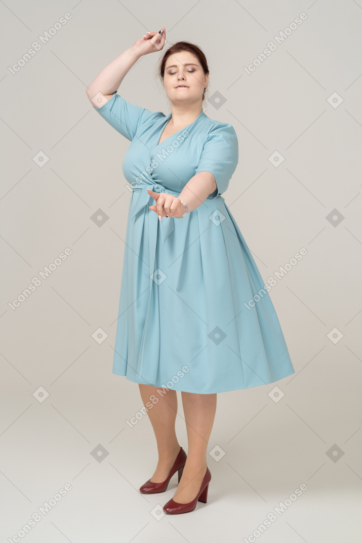 Vue de face d'une femme en robe bleue dansant