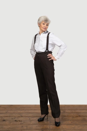 Mujer vestida formalmente posando con las manos en las caderas