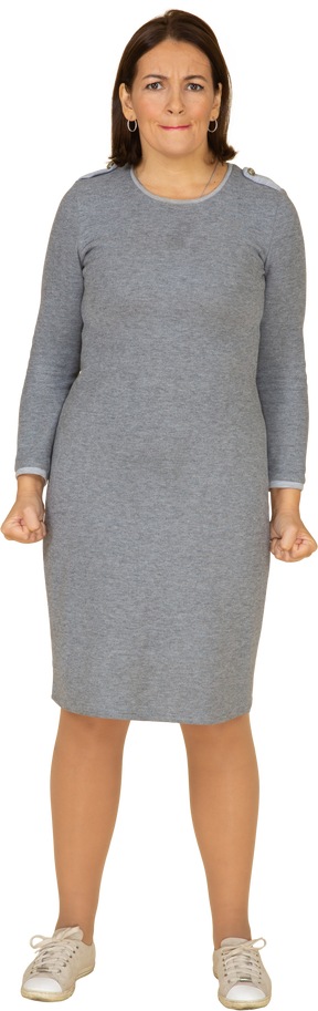 Vue de face d'une femme en robe grise faisant des grimaces