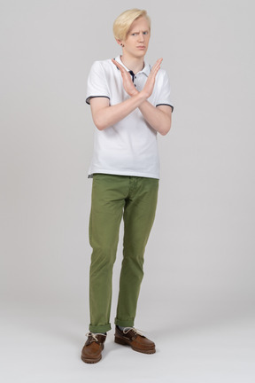 Young blond man showing stop gesture