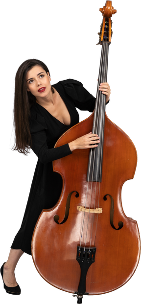 Front view of a young woman in black dress playing the double-bass wile looking up