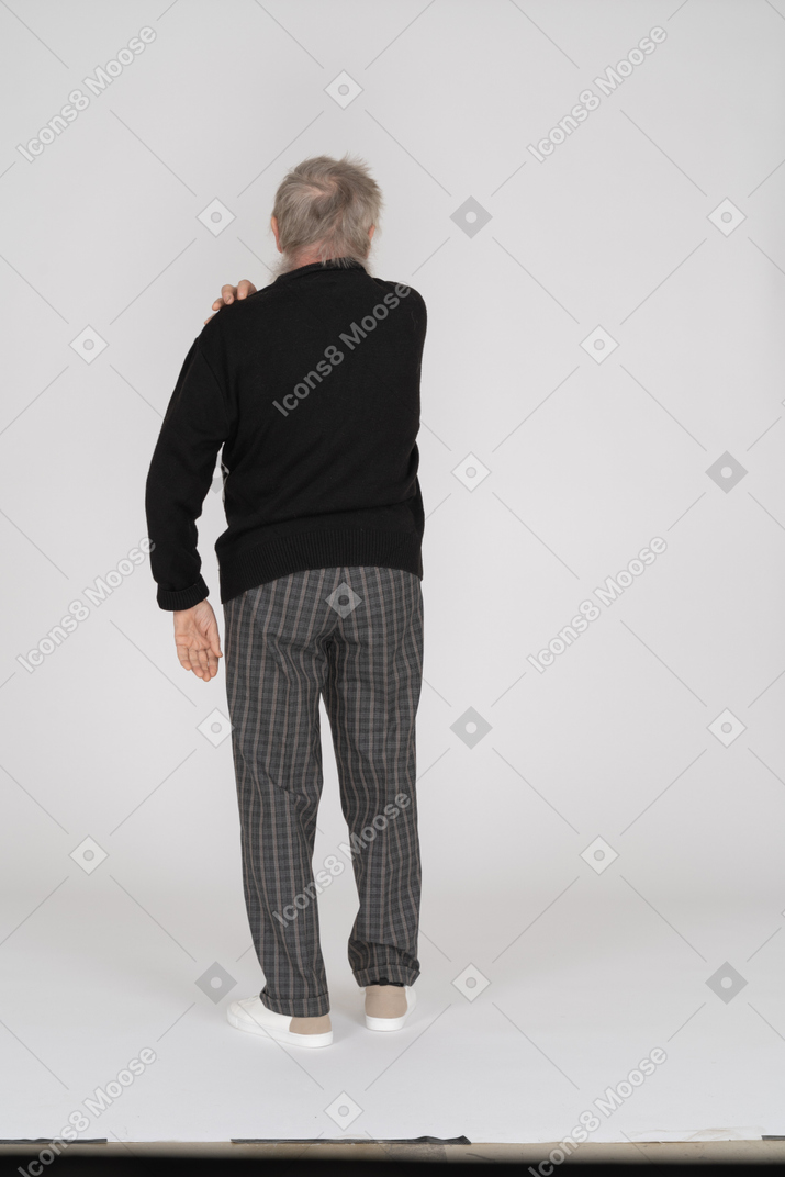Back view of a senior man touching his shoulder