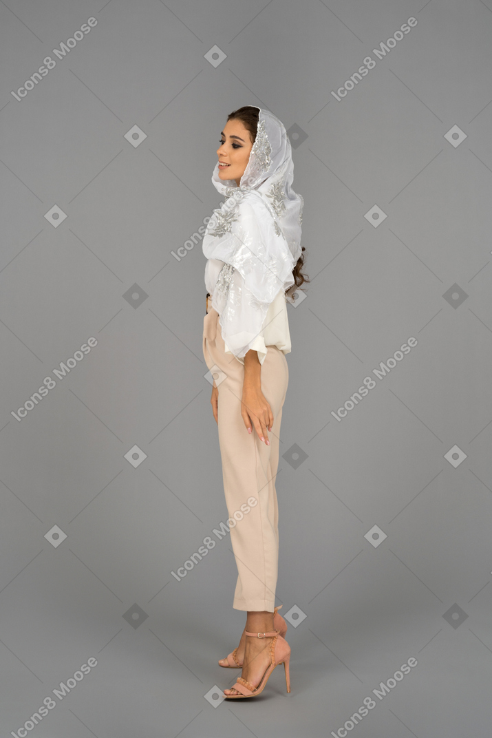Cheerful middle eastern woman standing still in profile
