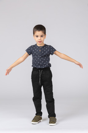 Front view of a cute boy standing with outstretched arms